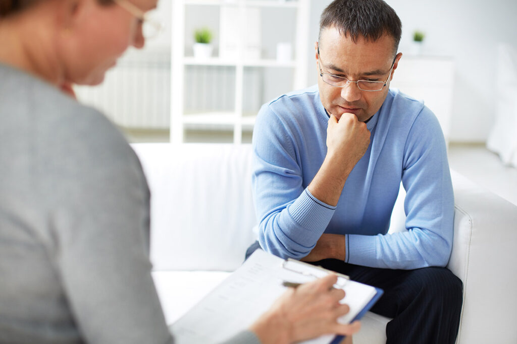 therapist explaining the 5 benefits of substance abuse treatment to worried male client